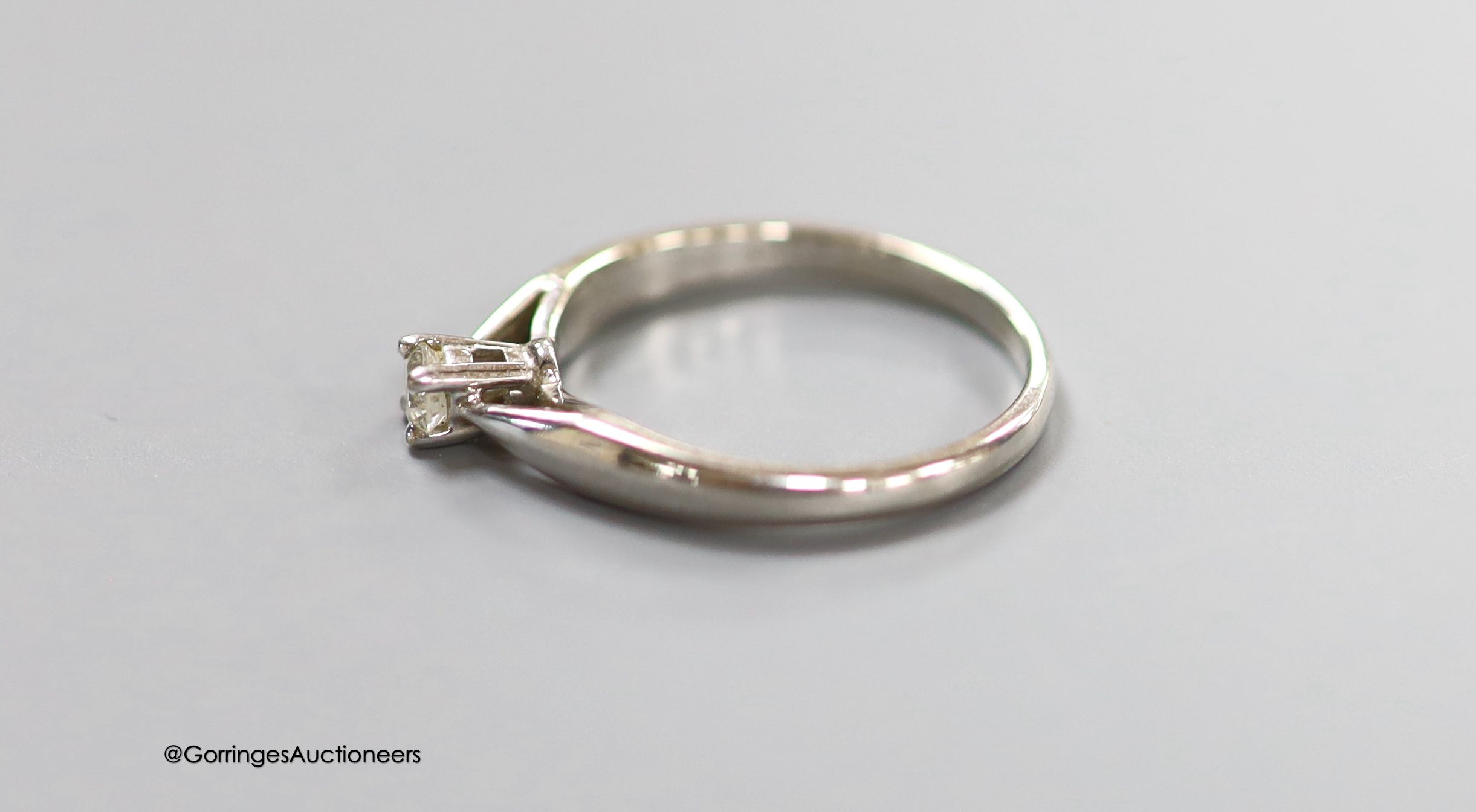 A modern 14ct white gold and solitaire diamond set ring, the stone weighing 0.15ct, size L, gross weight 2.1 grams.